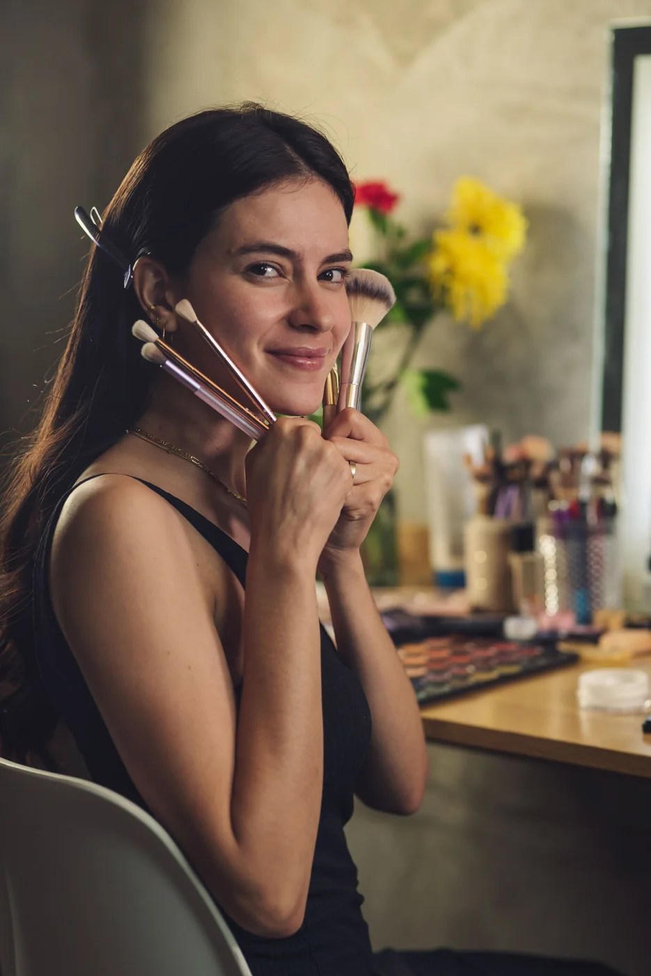 Mujer sosteniendo varias brochas de maquillaje